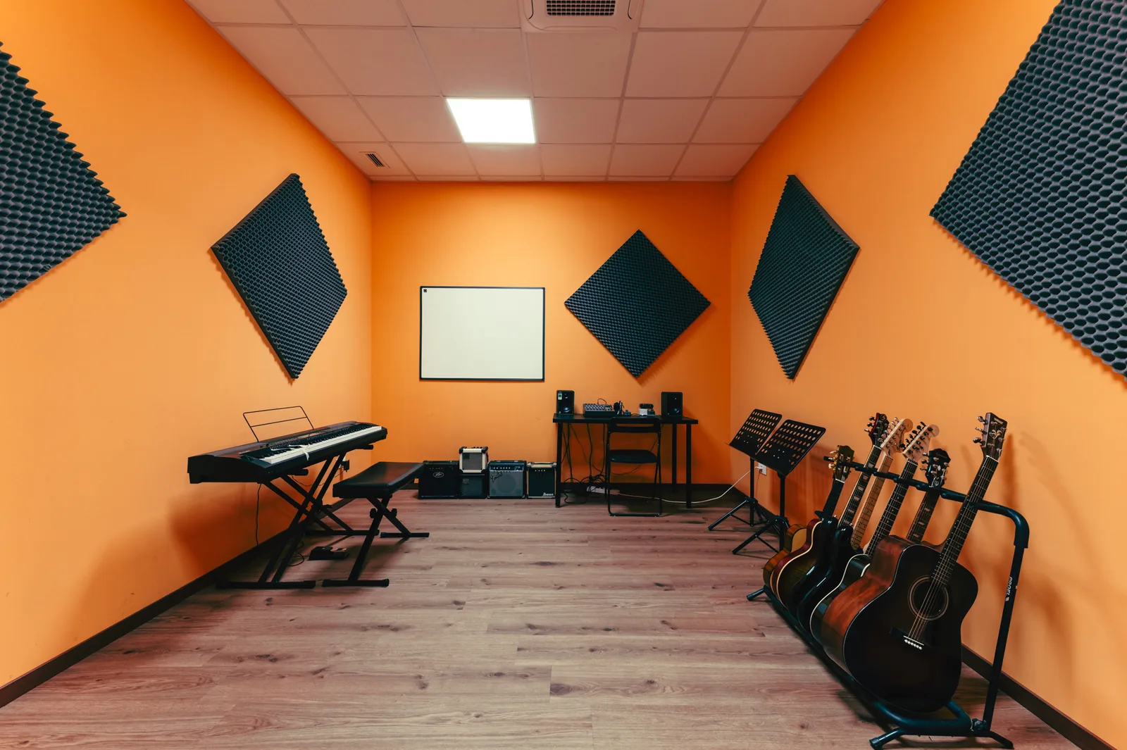 Aula arancione insonorizzata con chitarre e tastiera ad Artistation Faenza