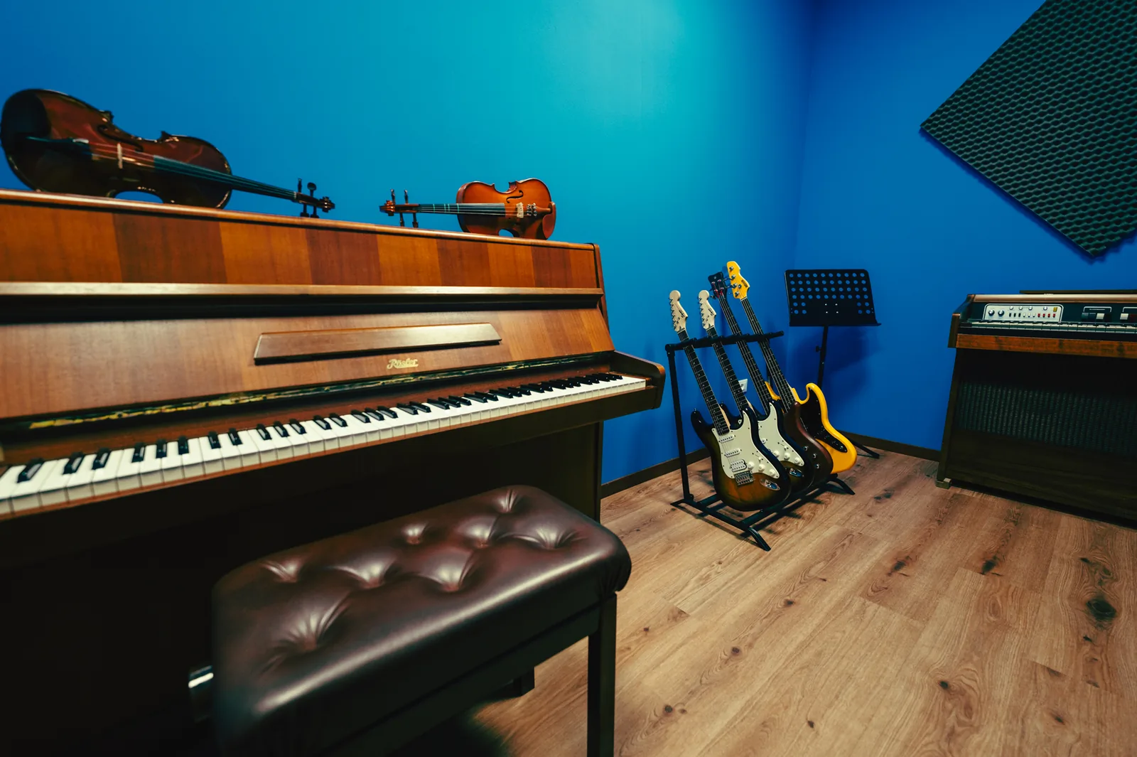 Aula blu con pianoforte, violini e chitarre ad Artistation Faenza