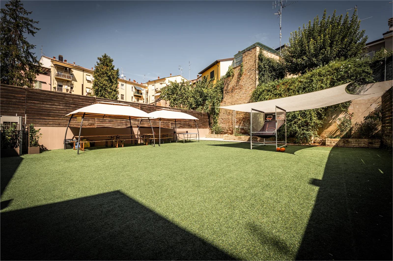 Cortile interno di Artistation a Faenza con prato e gazebo